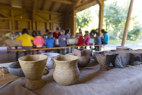 A group of pupils is doing a worksop dedicated to pottery