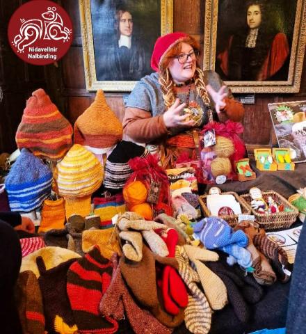 Emma behind her Nalbinding stall at 10th Century Traders, Jorvik Viking Festival 2025