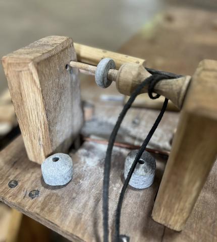 Tool Production This is the premise for a reconstruction of a small bench lathe used for turning soapstone disck for fabricating spindle whorls. The lathe spindle is powered by a reciprocating band, operated by an assistant.